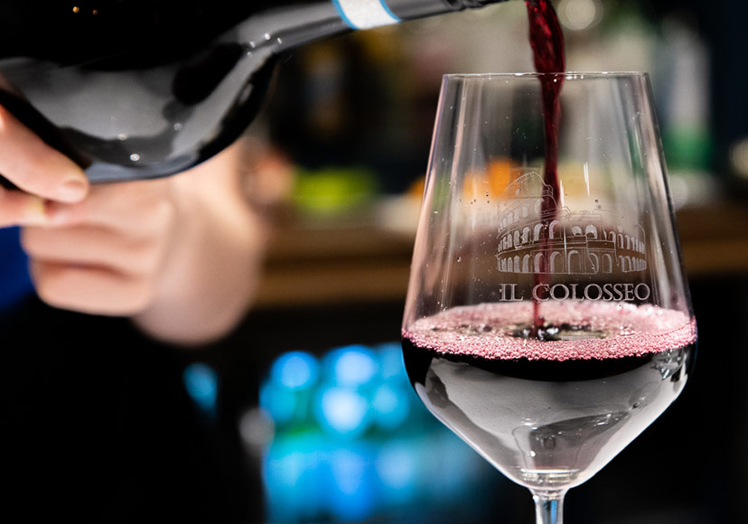 Waiter pouring a glass of red wine at Il Colosseo.